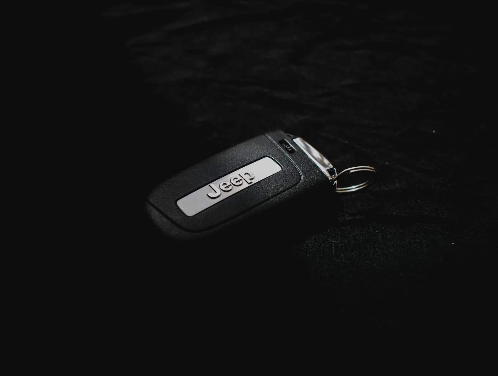 A car key fob on a dark surface
